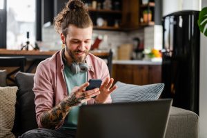 A-kassa, kuvituskuva, jossa henkilö katsoo puhelintaan