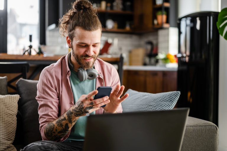 Henkilö katsoo puhelintaan iloisena
