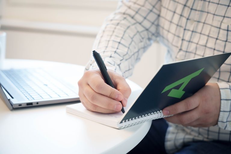 henkilö kirjoittaa A-kassan muistivihkoon