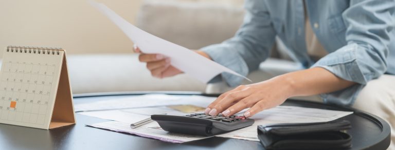 henkilö laskee laskimella paperi kädessä