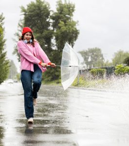 Kuvituskuva, jossa nainen pitelee sateenvarjoa ja vettä roiskuu 